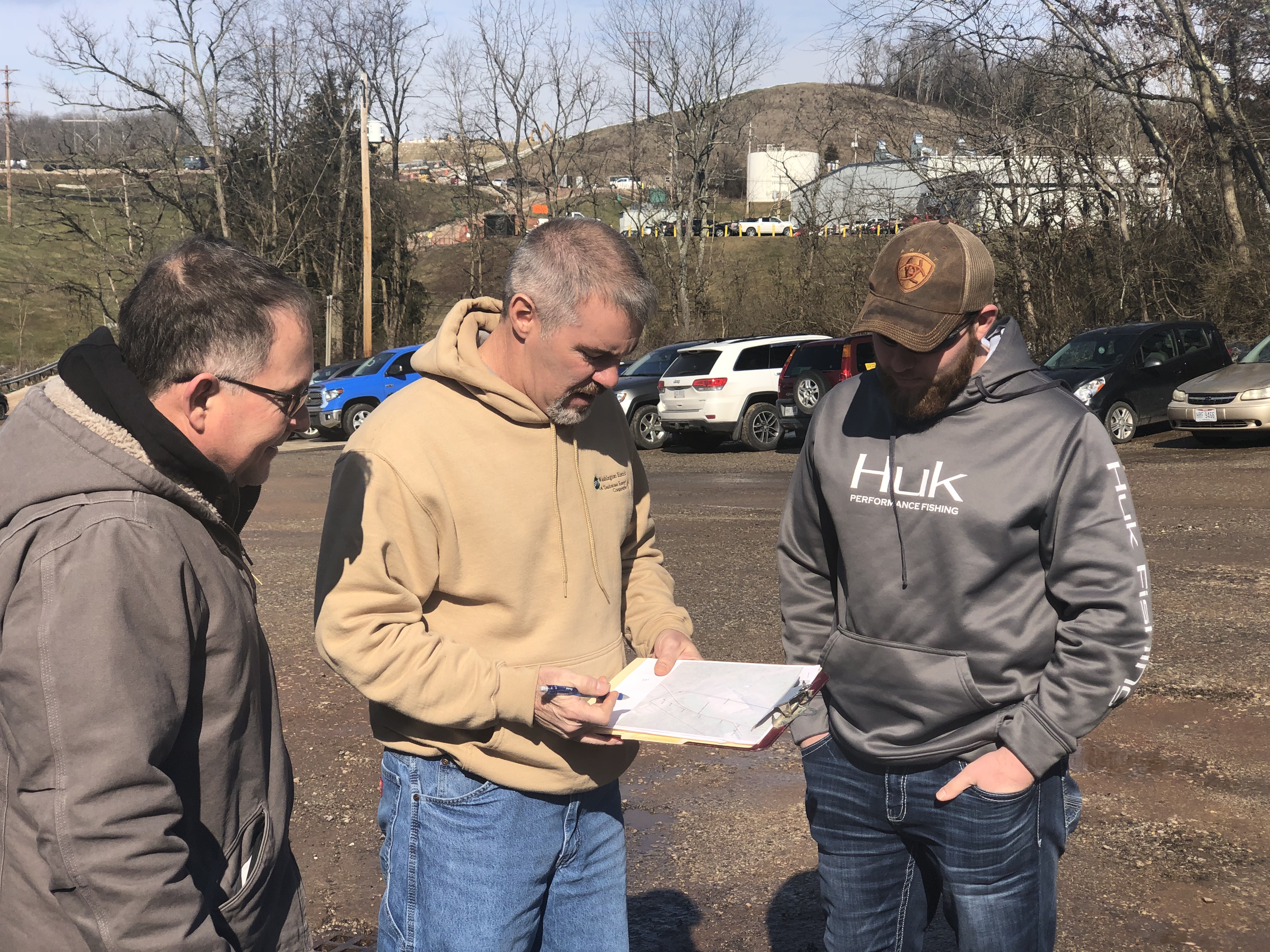 A field engineer meets with two men to discuss establish a new construction